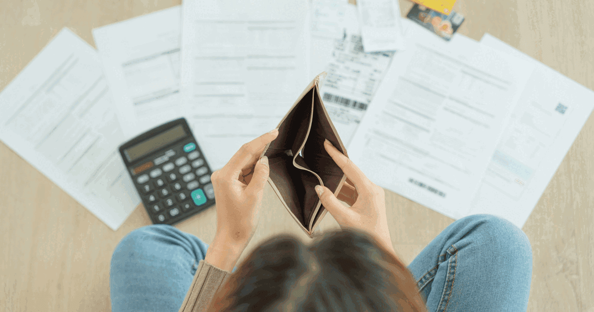 Stressed and headache woman with large bills or invoices, no money to pay expenses and credit card debt